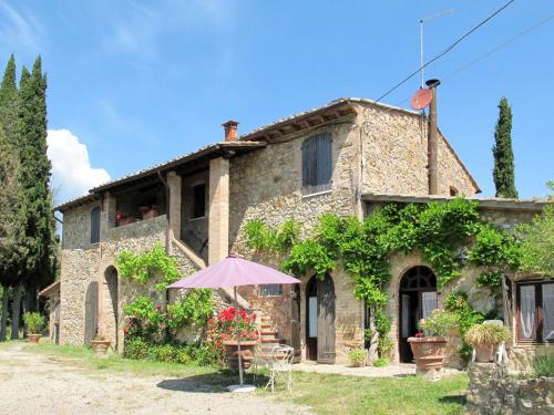 a house with an umbrella in front of it at Apartment Le Sodole - Petunia by Interhome in San Gimignano