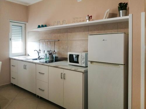 cocina con nevera blanca y microondas en Apartment Laura-2 by Interhome, en Castellammare di Velia
