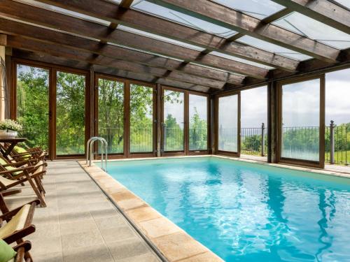 una piscina cubierta con ventanas y una gran piscina en Holiday Home General Massena - NAZ110 by Interhome, en Bene Vagienna
