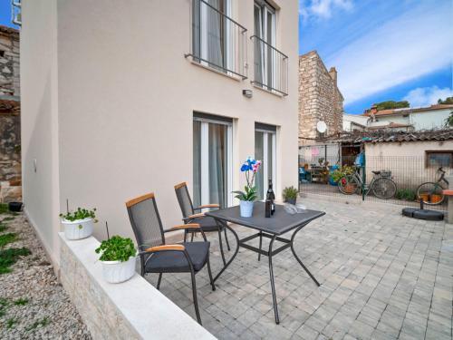 um pátio com uma mesa e cadeiras ao lado de um edifício em Holiday Home Dario by Interhome em Novigrad Istria