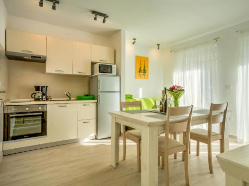 een keuken met een tafel en stoelen en een keuken met witte apparatuur bij Holiday Home Dario by Interhome in Novigrad Istria