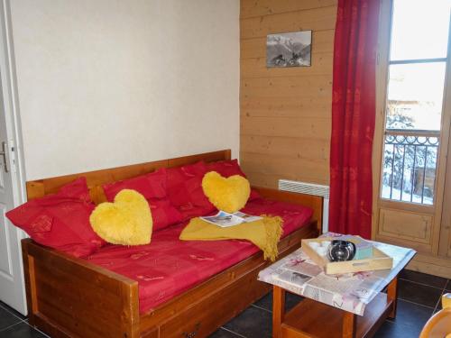 two heart cushions on a red couch in a room at Apartment Les erables by Interhome in Saint-Gervais-les-Bains