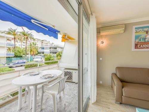 une salle à manger avec une table blanche et un canapé dans l'établissement Apartment Le Beach Garden by Interhome, à Cannes