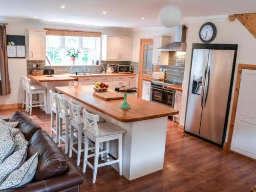 a kitchen with a large island with a wooden counter top at Holiday Home Feochan Bheag by Interhome in Kilmore