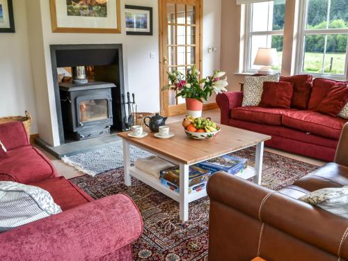 a living room with a table and a fireplace at Holiday Home Feochan Bheag by Interhome in Kilmore