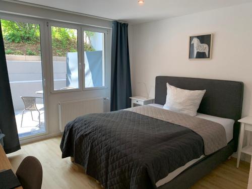 a bedroom with a bed and a large window at Hotel Markgraf in Bad Bellingen