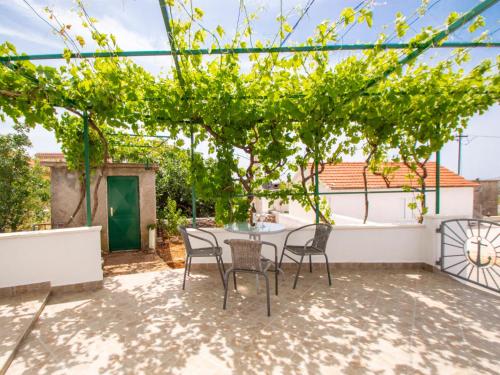 d'une terrasse avec une table et des chaises sous un arbre. dans l'établissement Holiday Home Snježana by Interhome, à Ražanj