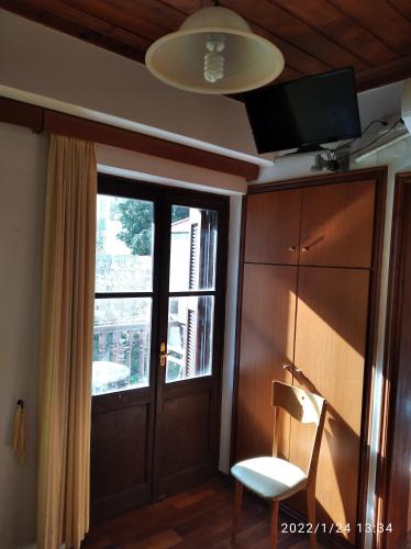 um quarto com uma porta, uma janela e uma cadeira em Stefanos em Meyisti