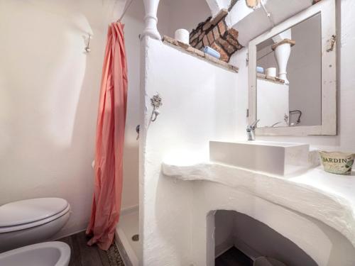 a white bathroom with a sink and a toilet at Apartment Palazzo Antiche Porte-1 by Interhome in Rimini