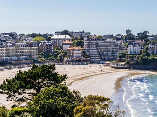 a beach in front of a city with buildings at Apartment Château des Deux Rives by Interhome in Dinard