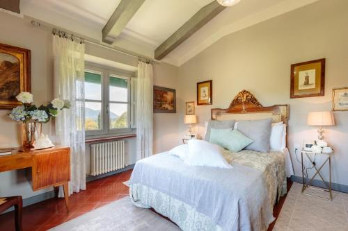 a bedroom with a bed and a window at Villa D'Amico, charming indulgence overlooking Lucca Town Centre in Lucca