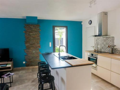 La FavièreにあるVilla Bartavelles by Interhomeの青い壁のキッチン、カウンター(スツール付)
