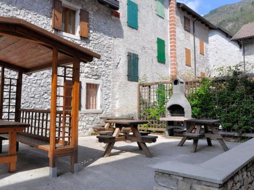 a picnic table and a grill next to a building at Apartment Albergo Diffuso - Cjasa Ustin-5 by Interhome in Barcis