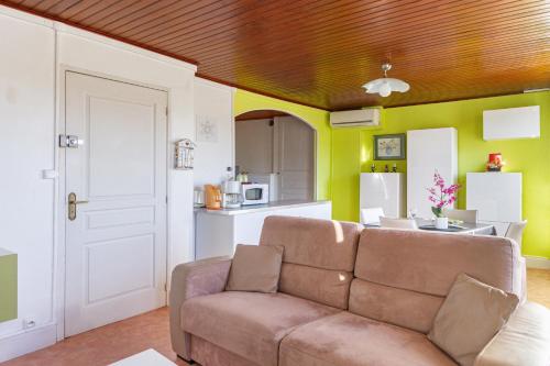 a living room with a couch and a kitchen at Le Barry in Murat