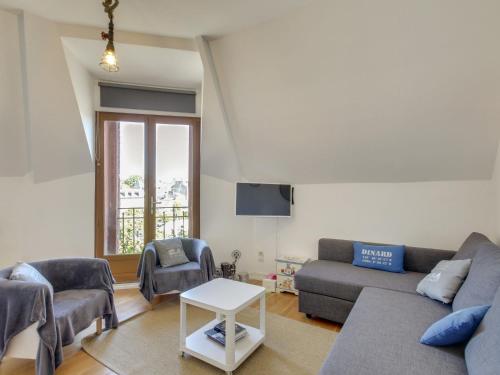 uma sala de estar com um sofá e uma mesa em Apartment Basse Vallée by Interhome em Dinard
