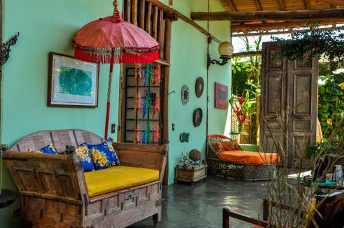 a living room with a chair and an umbrella at Gaia Gardens Pousada in Paraty