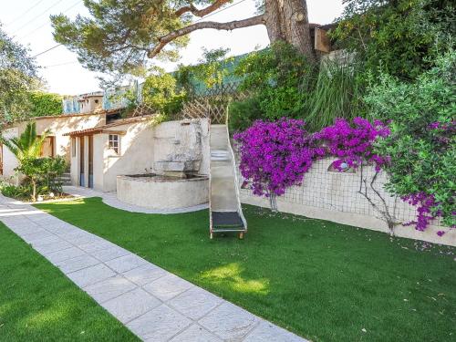 a playground in a yard with purple flowers at Holiday Home Nicoleine by Interhome in Cagnes-sur-Mer