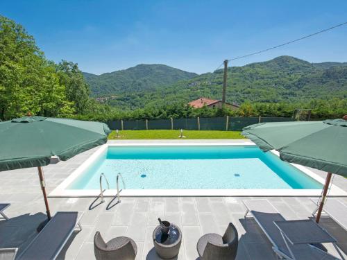 ein Swimmingpool mit Stühlen und Sonnenschirmen in der Unterkunft Holiday Home Agr- Castello della Mugazzena by Interhome in Tresana