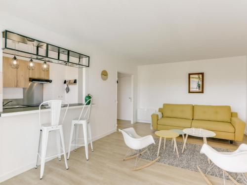 een woonkamer met een bank en een tafel en stoelen bij Apartment Le clos Xapella by Interhome in Bidart