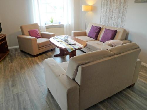 ein Wohnzimmer mit einer Couch und zwei Stühlen und einem Tisch in der Unterkunft Apartment Alina by Interhome in Marienhafe