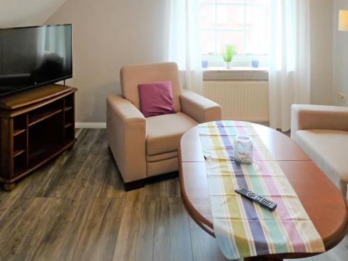 ein Wohnzimmer mit einem Couchtisch und einem TV in der Unterkunft Apartment Alina by Interhome in Marienhafe