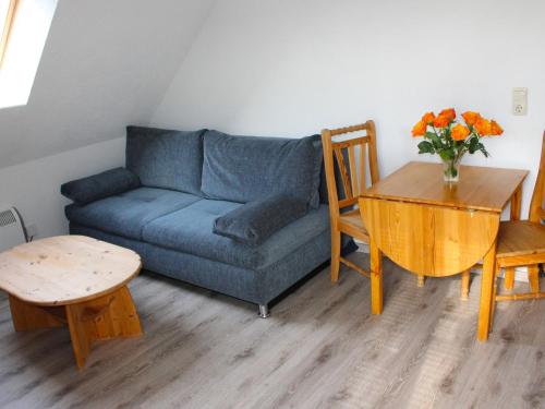 a living room with a blue couch and a table at Apartment Gollwitzer Park - Insel Poel-4 by Interhome in Gollwitz