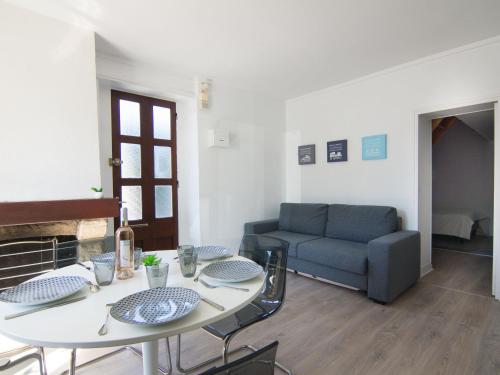 ein Wohnzimmer mit einem Tisch und einem Sofa in der Unterkunft Apartment Le Petit Robinson-8 by Interhome in La Richardais