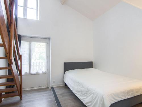 une petite chambre avec un lit et un escalier dans l'établissement Apartment Le Petit Robinson-8 by Interhome, à La Richardais