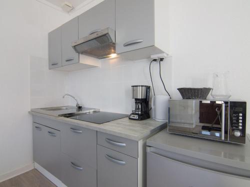 eine Küche mit einer Spüle und einer Mikrowelle in der Unterkunft Apartment Le Petit Robinson-8 by Interhome in La Richardais