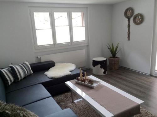 a living room with a blue couch and a coffee table at Apartment Bergfreude Kuonen by Interhome in Saas-Grund