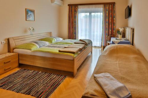 a bedroom with a large bed and a window at Gasthof Bader in Deutsch Goritz