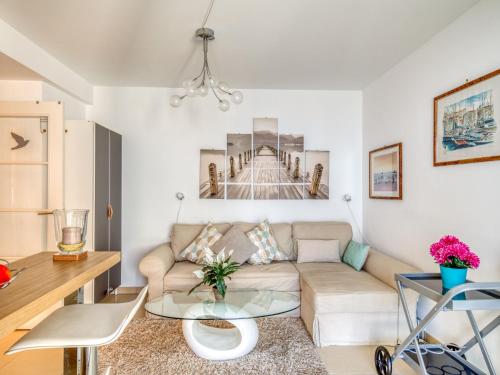 a living room with a couch and a table at Apartment Le Newport-2 by Interhome in Fréjus