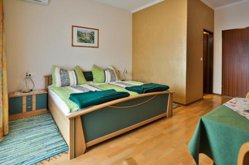 a bedroom with a large bed with green sheets at Gasthof Bader in Deutsch Goritz