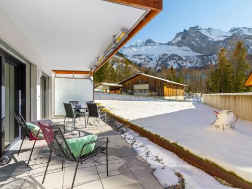 a patio with chairs and a table and mountains at Apartment Terrasse by Interhome in Kandersteg
