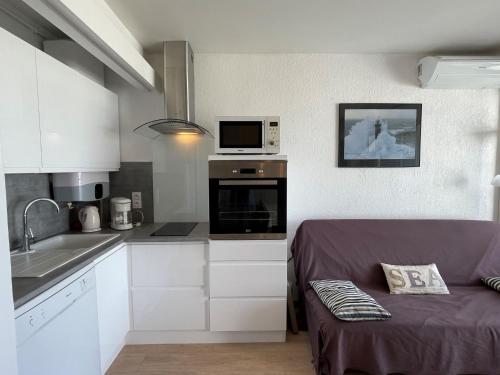 Il comprend une petite cuisine avec un canapé et un four micro-ondes. dans l'établissement Apartment Résidence du Golfe by Interhome, au Grau-du-Roi