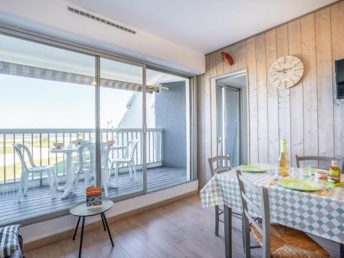 une salle à manger avec une table et un balcon dans l'établissement Apartment Résidence du Golfe by Interhome, au Grau-du-Roi