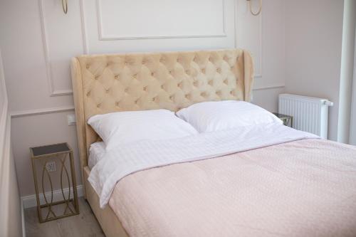 a bedroom with a large bed with a tufted headboard at Apartament Baltic Lux Sztutowo in Sztutowo