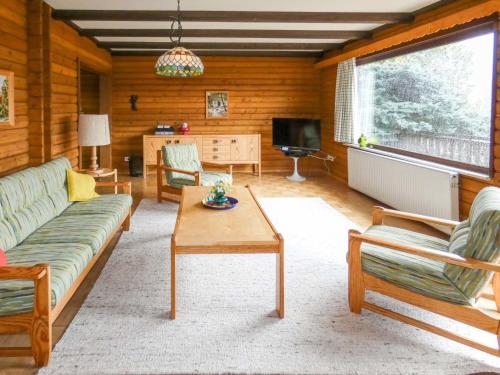 ein Wohnzimmer mit einem Sofa und einem Tisch in der Unterkunft Apartment Am Hohen Bogen-23 by Interhome in Arrach