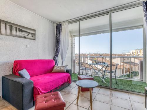 - un salon avec un canapé rouge et une grande fenêtre dans l'établissement Apartment Les Saladelles-10 by Interhome, au Grau-du-Roi