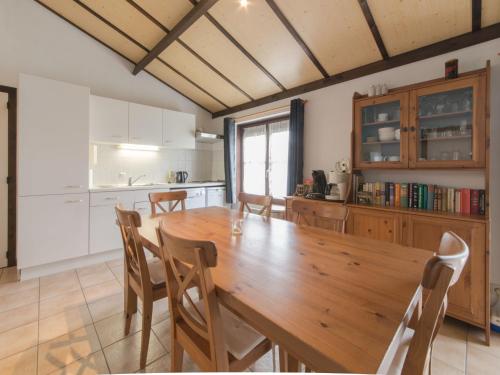 デ・ハーンにあるHoliday Home Polderhuis nr-142 by Interhomeの木製のテーブルと椅子のあるキッチンとダイニングルーム