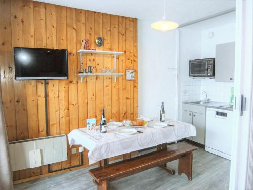 Il comprend une cuisine avec une table et une télévision murale. dans l'établissement Apartment Mélèzes 33 by Interhome, aux Menuires