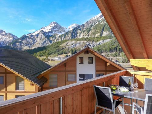 a balcony with a table and chairs and mountains at Apartment Momento by Interhome in Kandersteg