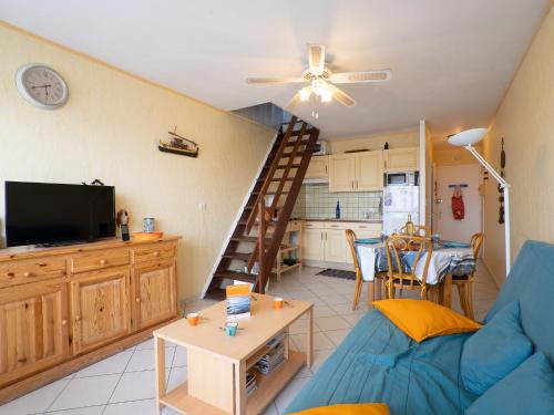 un salon avec un canapé bleu et une cuisine dans l'établissement Apartment Hippocampe by Interhome, au Grau-du-Roi