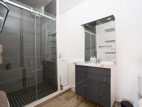 une salle de bain avec une douche en verre et un lavabo dans l'établissement Apartment Le Nirvana-2 by Interhome, au Grau-du-Roi