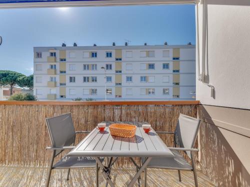 een tafel en stoelen op een balkon met een gebouw bij Studio Le Mercure by Interhome in Le Grau-du-Roi