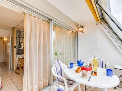 une table blanche et des chaises dans une pièce avec une fenêtre dans l'établissement Studio Escale Plage-2 by Interhome, au Grau-du-Roi