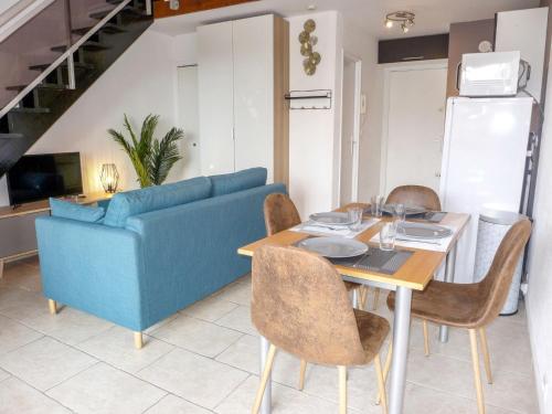 un salon avec un canapé bleu et une table dans l'établissement Studio Les Caroubiers-1 by Interhome, à Saint-Aygulf