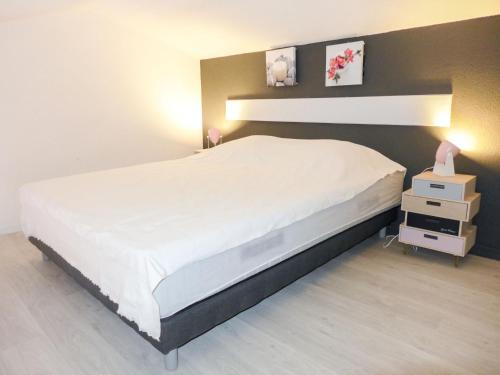 - une chambre avec un grand lit blanc et une table de chevet dans l'établissement Studio Les Caroubiers-1 by Interhome, à Saint-Aygulf