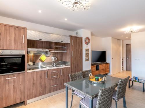 une cuisine avec des armoires en bois et une table avec des chaises dans l'établissement Studio Château-20 by Interhome, à Porto-Vecchio