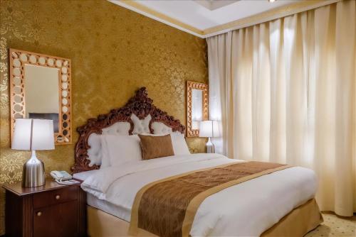 Crystal Plaza Al Majaz Hotel في الشارقة: غرفة نوم بسرير كبير ومرآة